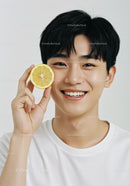 Young Man with Fresh Lemon Half Smiling Brightly in White Background