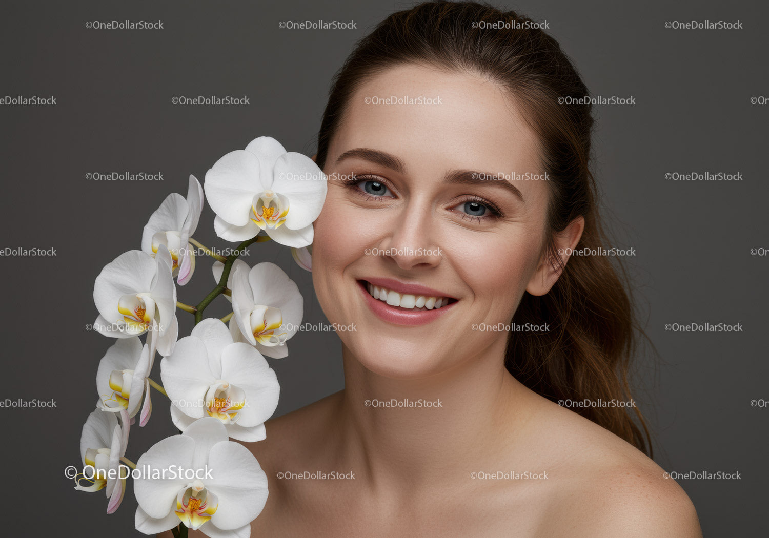 Piękna uśmiechnięta kobieta z białymi kwiatami orchidei w portrecie studyjnym