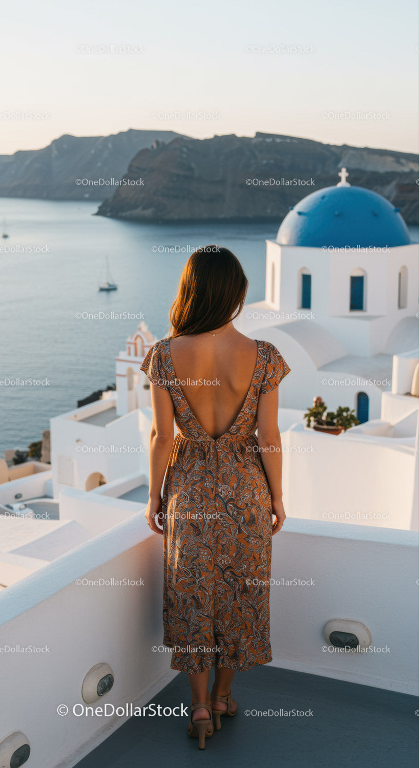 Kobieta podziwiająca zachód słońca na Santorini w Grecji