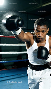 Focused boxer throwing a powerful punch in gym ring