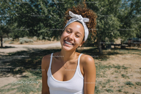 Joyful Woman Smiling Outdoors in Sunlit Park