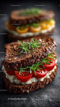 Gourmet Dark Bread Sandwich with Cherry Tomatoes and Fresh Herbs