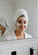 Smiling young woman with skincare mask and eye patches