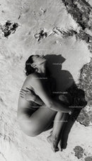 Serene woman embracing herself lying on natural surface