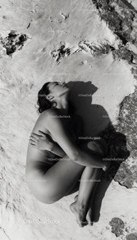 Serene woman embracing herself lying on natural surface