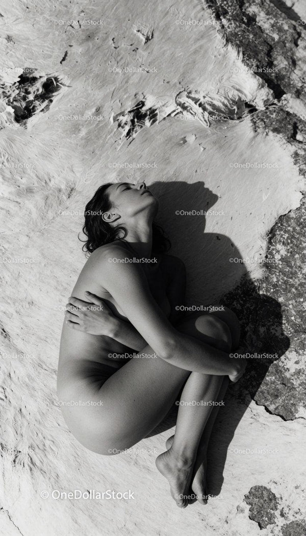 Serene woman embracing herself lying on natural surface