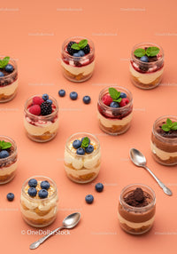 Assorted layered desserts in jars with fresh berries