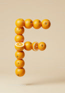 Letter F formed with fresh whole and sliced oranges