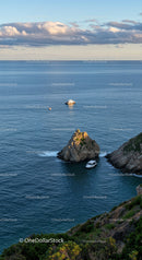 Scenic Coastal Seascape with Boats and Rocky Cliffs at Sunset