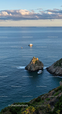 Scenic Coastal Seascape with Boats and Rocky Cliffs at Sunset