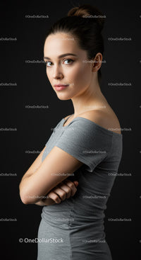 Elegant Woman in Gray Dress with Confident Pose Against Black Background