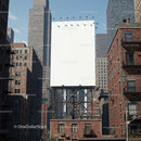 Empty billboard towering over urban brick buildings