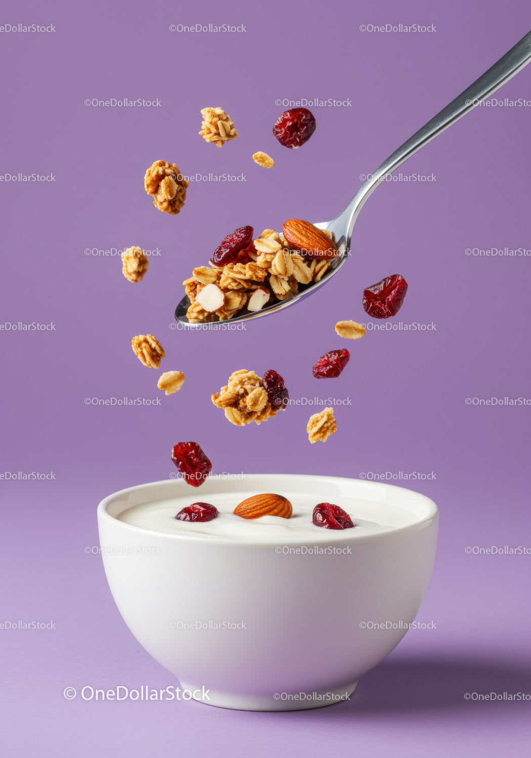 Spoonful of granola and dried berries over yogurt bowl
