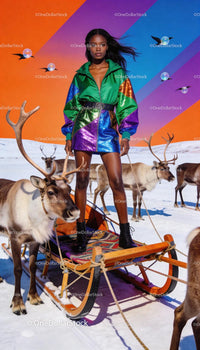 Confident woman in vibrant outfit riding reindeer sled