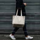 Person Walking with Neutral Canvas Tote Bag by Wall