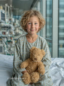 Smiling Young Boy with Teddy Bear in Bright Hospital Room