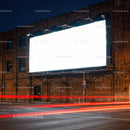 Illuminated blank billboard on brick building at night