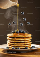 Stack of fluffy pancakes with honey and fresh blueberries