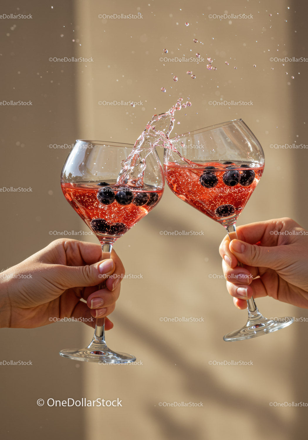 Two hands clinking glasses with sparkling berry drinks