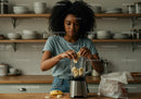 Young woman preparing healthy banana smoothie in modern kitchen