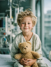 Smiling Young Boy with Teddy Bear in Hospital Room