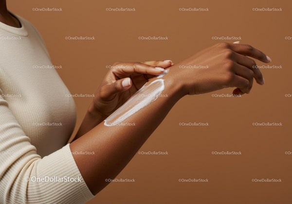 Close-up of Woman Applying Sunscreen Lotion to Arm for Sun Protection