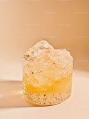 Close-up of translucent yellow mineral stone on beige background