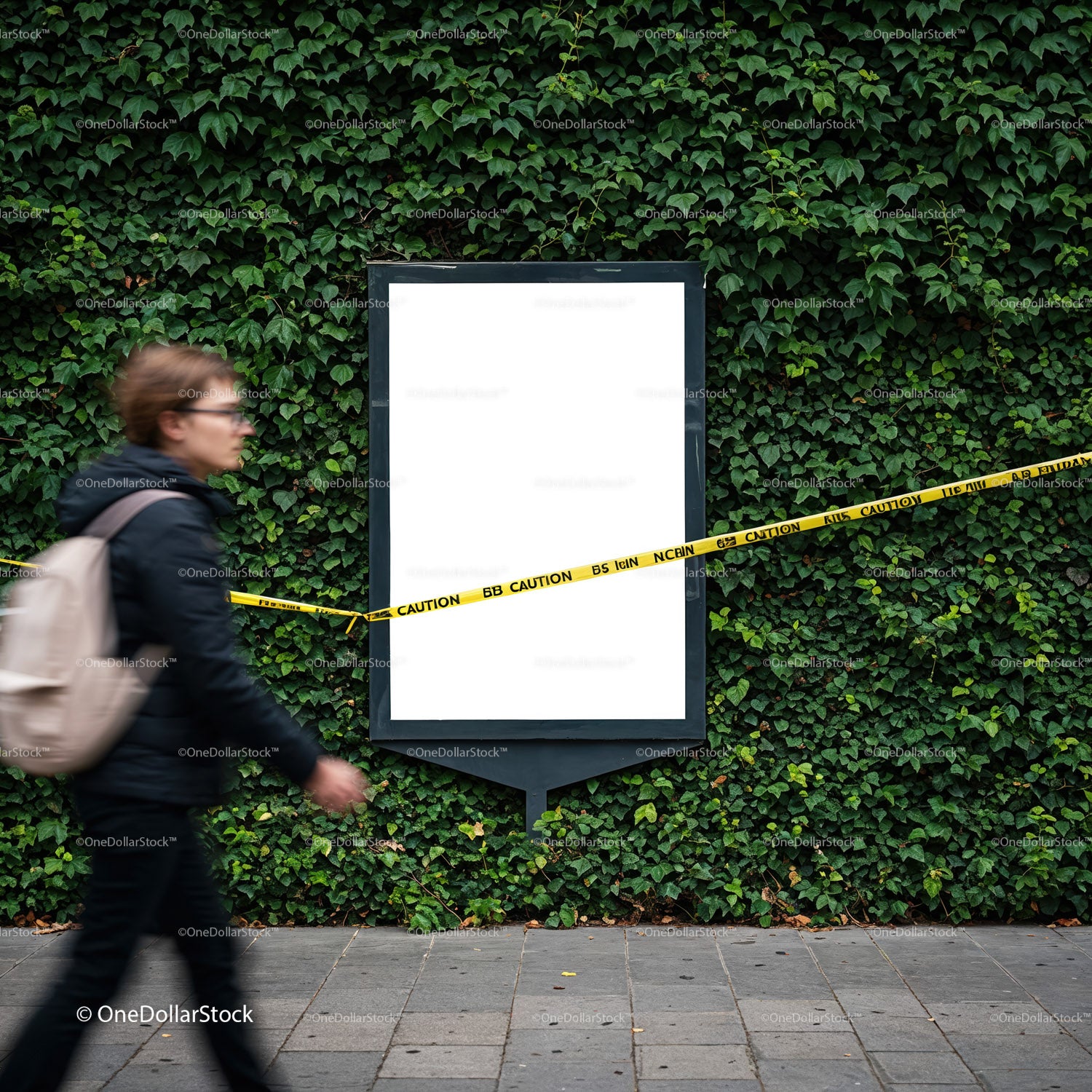 Osoba przechodząca obok pustego billboardu z taśmą ostrzegawczą i ścianą porośniętą bluszczem