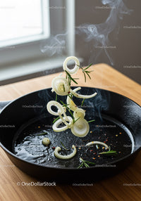 Sizzling onion rings with fresh rosemary in cast iron pan