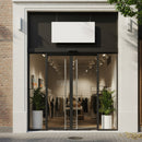Modern clothing boutique with glass entrance and greenery