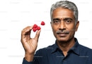 Elderly Man Enjoying Fresh Raspberries for Healthy Living