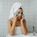 Woman applying under eye patches during self care routine