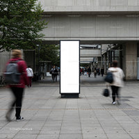 Blank vertical billboard in busy urban pedestrian area