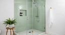 Modern bathroom with green tiled shower and plants