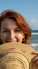 Smiling Woman with Red Hair Holding Straw Sunhat at Beach