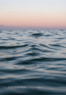 Serene Ocean Waves at Sunset with Pink Sky and Calm Water