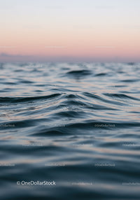 Serene Ocean Waves at Sunset with Pink Sky and Calm Water