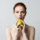 Red-Haired Woman Holding Pear in Minimalist Portrait