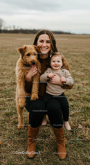Smiling mother with toddler and dog in autumn field