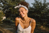 Smiling Woman With Curly Hair and Headband Enjoying Outdoors