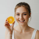 Bright Young Woman Holding Fresh Orange Slice with Smile