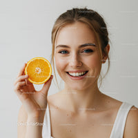 Bright Young Woman Holding Fresh Orange Slice with Smile