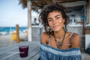 Smiling Woman with Curly Hair at Beachside Cafe in Summer