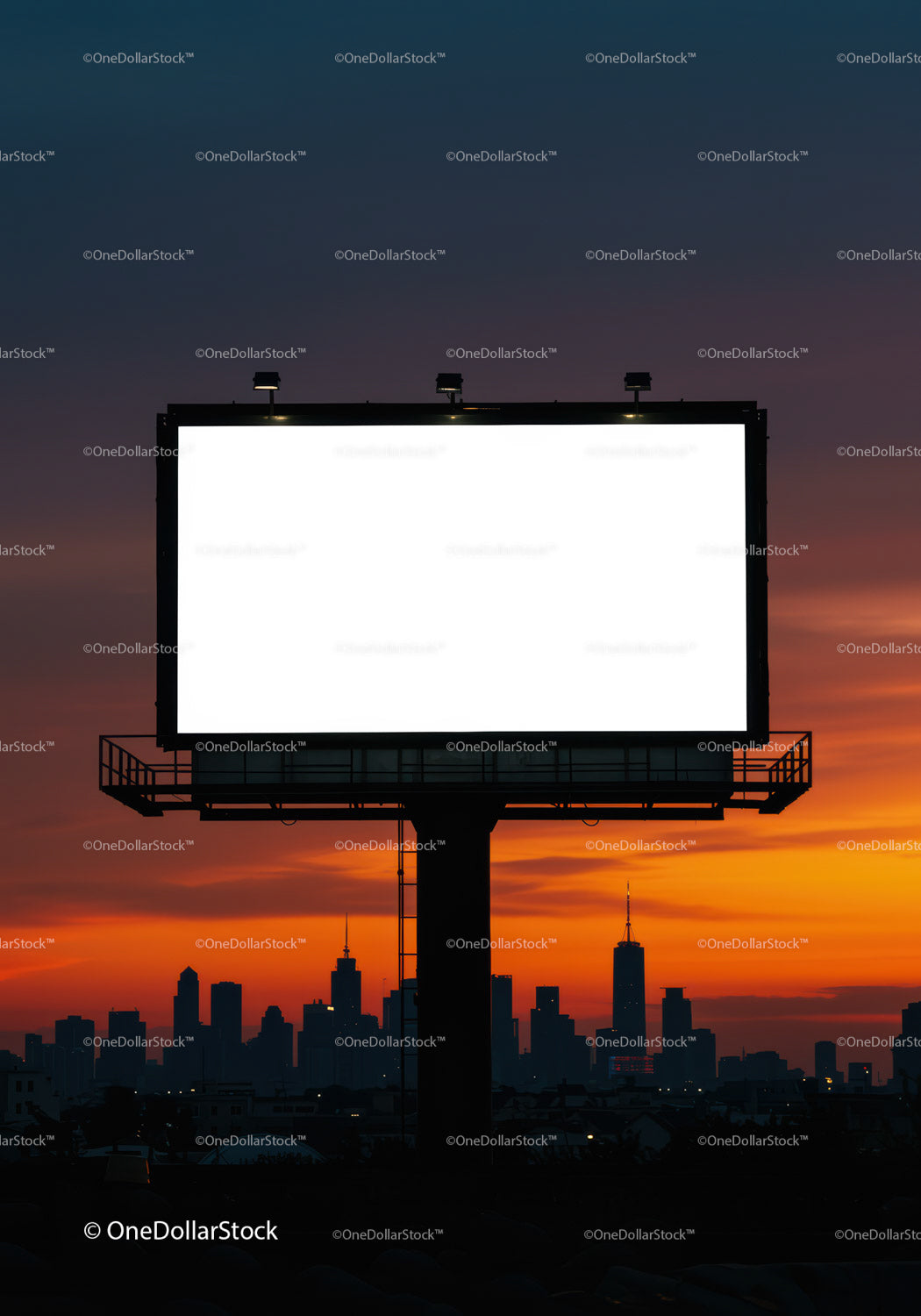 Empty illuminated billboard against city skyline at sunset
