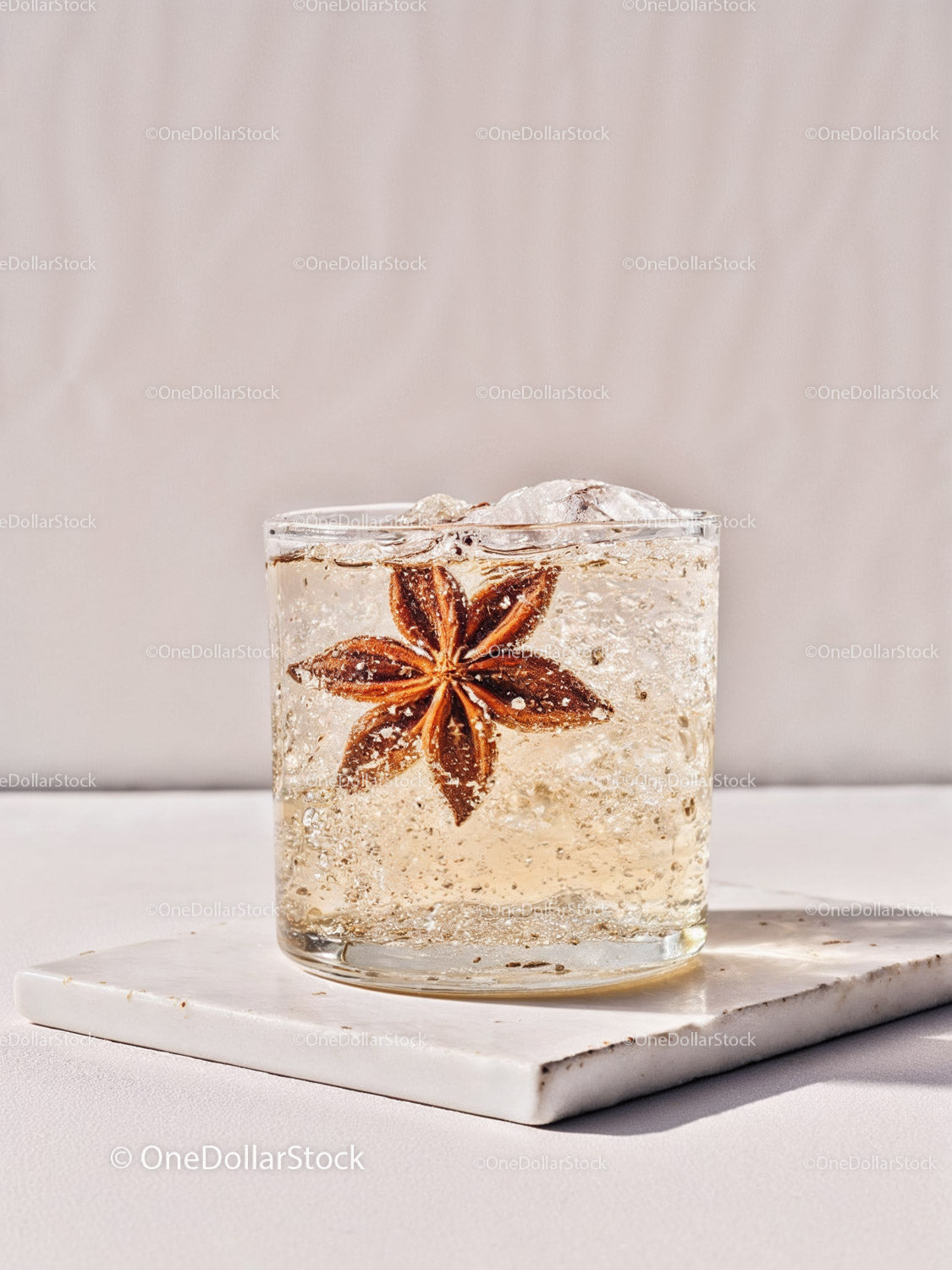 Refreshing cocktail with star anise garnish and ice cubes