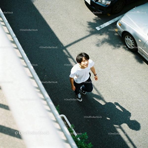 Young man walking outdoors under bright sunlight