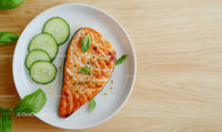 Fresh Grilled Salmon Steak with Cucumber and Basil on White Plate