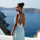 Elegant woman in blue dress overlooking serene sea view