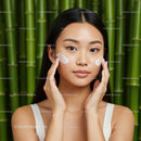 Young Asian Woman Applying Face Cream in Natural Bamboo Setting