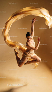 Graceful dancer in mid-air leap with flowing fabric